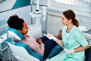 dental assistant and her patient talking at a dental clinic.